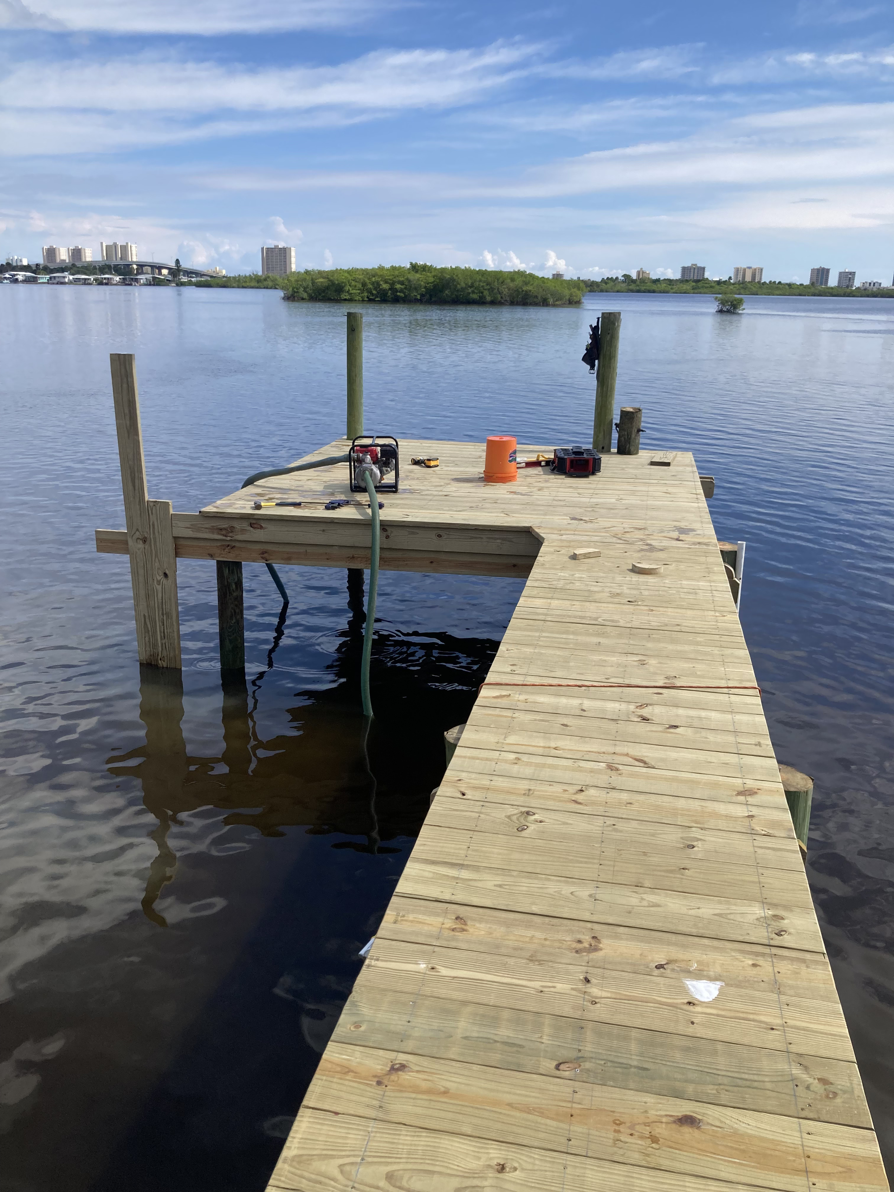 Freshly built dock platform extending over open Florida waterway with city skyline beyond
