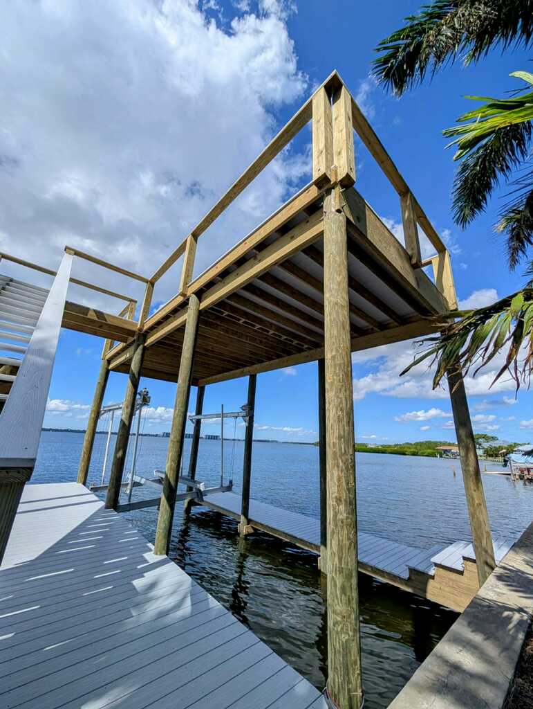 Boat lift structure and covered dock framing over open water