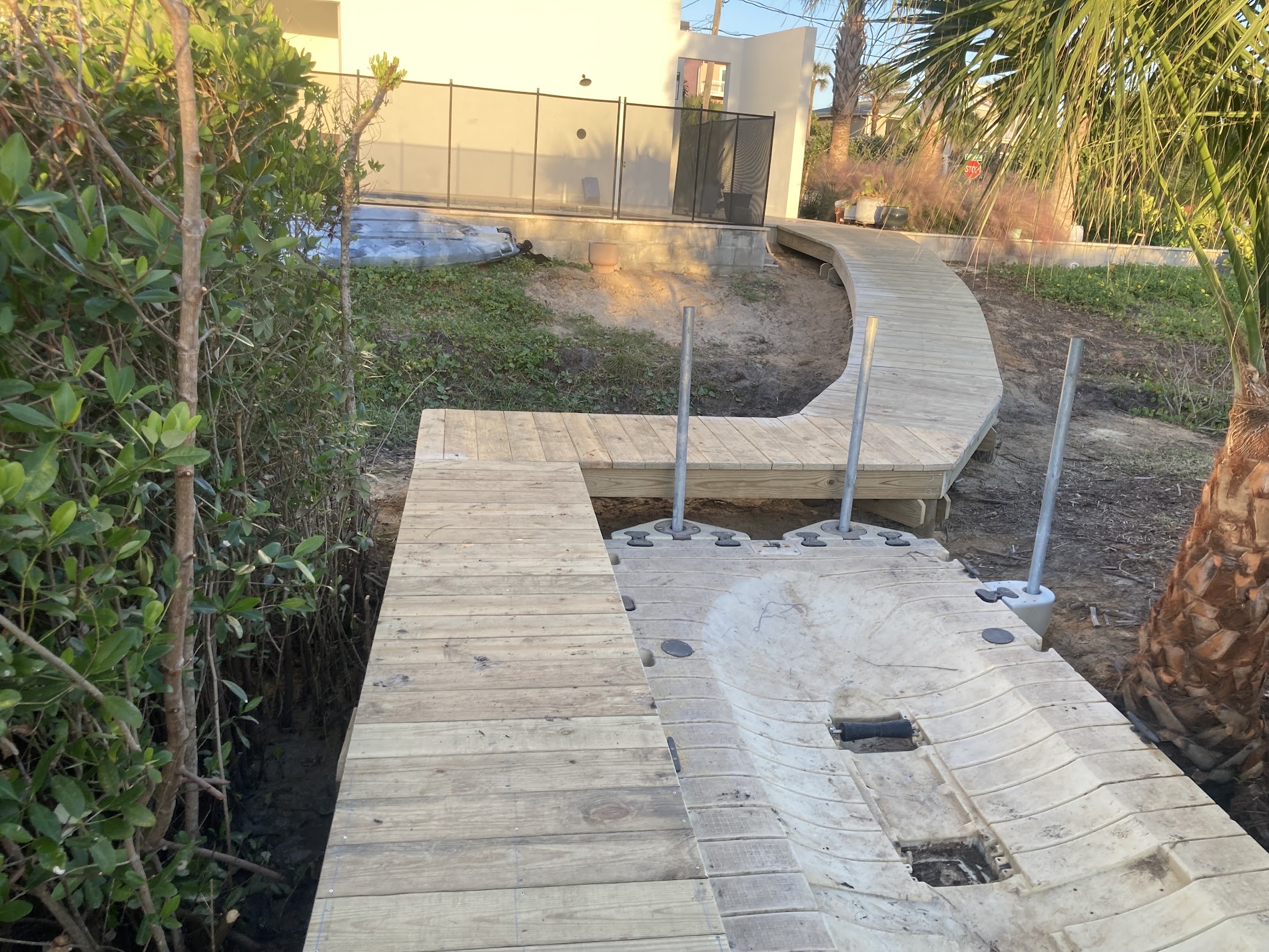 Curved dock walkway leading to a floating dock platform under construction