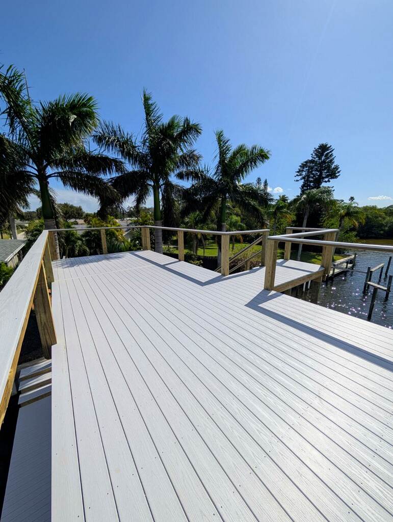 Upper sun deck of a waterfront dock structure surrounded by palm trees